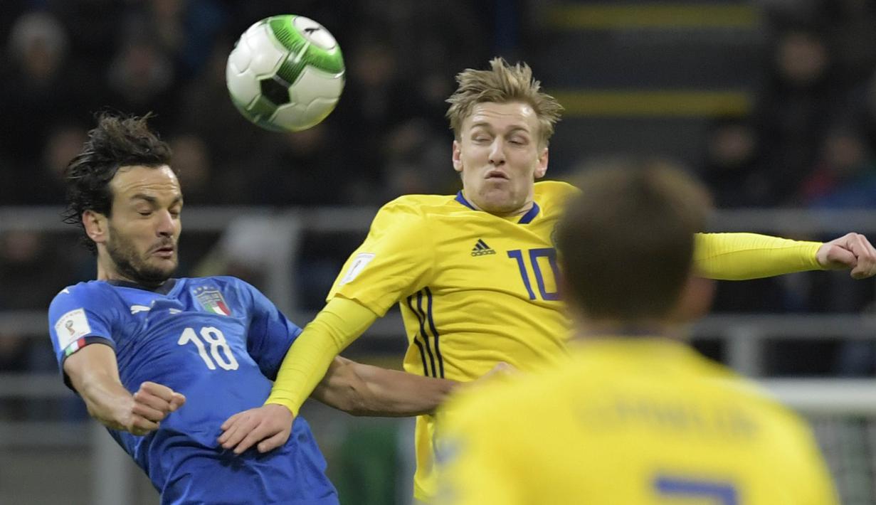 Gelandang Italia, Marco Parolo, duel udara dengan gelandang Swedia, Emil Forsberg, pada laga leg kedua playoff Piala Dunia 2018, di Stadion Giuseppe Meazza, Senin (13/11/2017). Italy bermain imbang 0-0 dengan Swedia. (AFP/Miguel Medina)