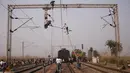 Petugas melepaskan kabel listrik yang rusak terkena sambaran dua kereta penumpang yang bertabrakan di Palwal, India, Selasa (8/12). Menurut media setempat, kejadian itu menewaskan satu orang dan puluhan lainnya luka parah. (REUTERS/Anindito Mukherjee)