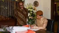Presiden Jokowi (kanan) didampingi Sekretaris Kabinet Andi Widjajanto (kiri) menandatangani berkas-berkas saat berkantor di rumahnya di Jalan Kutai Utara RT.08/RW.07 Sumber, Solo, Jateng, Rabu (10/6/2015). (Liputan6.com/Faizal Fanani)