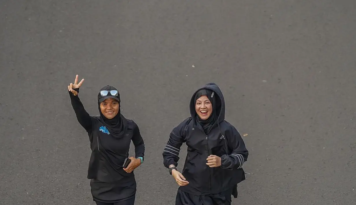 Ia memadukan oversized parka jacket dengan rok legging hitam dan sneakers putih [@natasharizkynew]