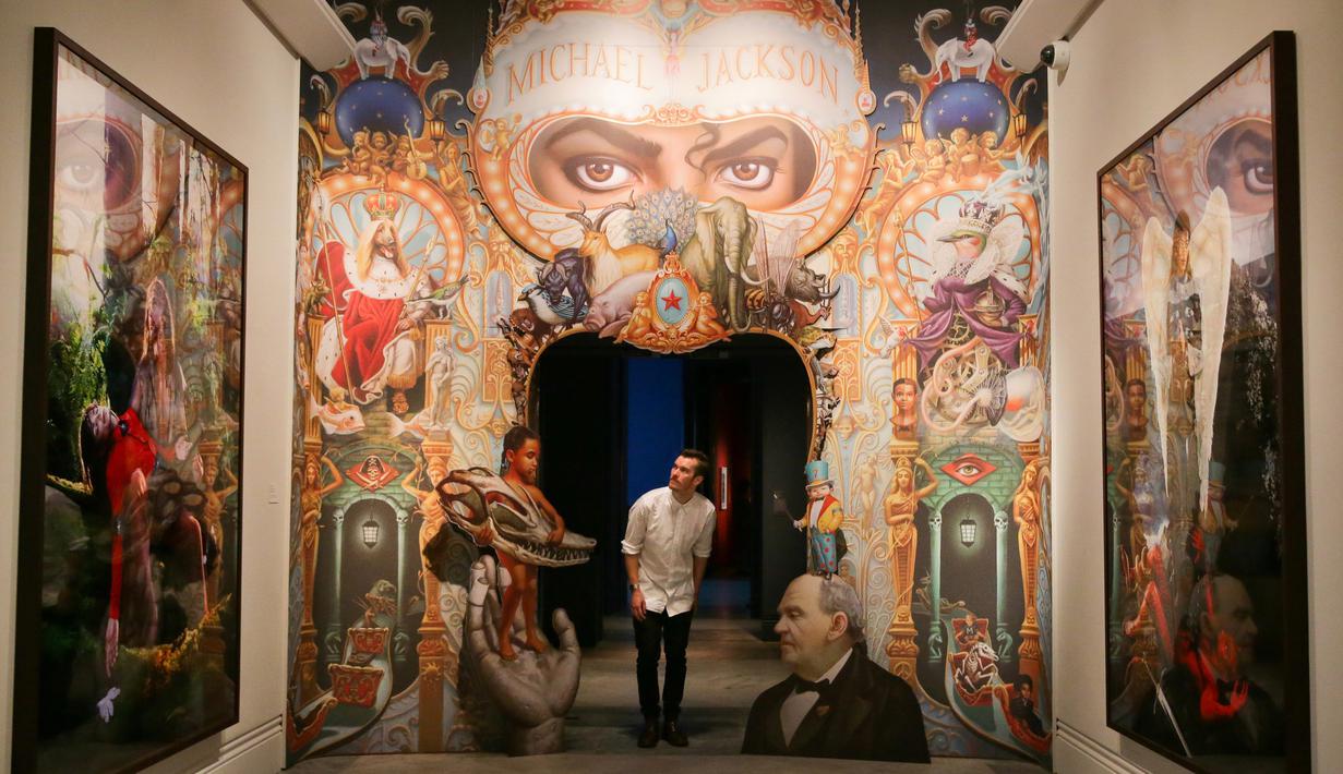 Petugas berpose dekat karya seni seniman AS Mark Ryden pada pameran 'Michael Jackson: On The Wall' di National Potrait Gallery, London, Rabu (27/6). Dalam pameran ini, karya-karya yang dihasilkan lebih dari 40 seniman dipamerkan. (Daniel LEAL-OLIVAS/AFP)
