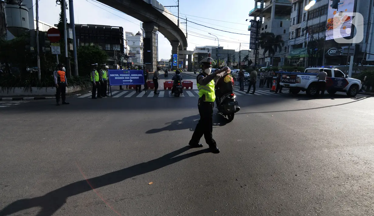 Polisi mengatur arus lalu lintas saat penyekatan masa PPKM Darurat di Perempatan Fatmawati, Jakarta, Senin (12/7/2021). Hanya dokter, paramedis, ambulans, darurat dan pengendara bermotor yang dapat menujukkan STRP yang boleh melintas. (merdeka.com/Arie Basuki)