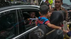 Presiden Joko Widodo membagikan buku kepada warga seusai acara makan siang bersama kepala negara serta delegasi negara-negara peserta Konferensi Asia Afrika di Jalan Cicendo, Bandung, Jumat (24/4/2015). (Liputan6.com/Faizal Fanani)