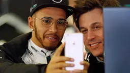 Lewis Hamilton berselfie dengan rekannya saat bersiap untuk memulai latihan kedua pers Formula One Grand Prix di Melbourne, Australia, (17/03/16). Ia sempat menjadi juara dunia termuda sepanjang sejarah F1. (REUTERS/Brandon Malone)