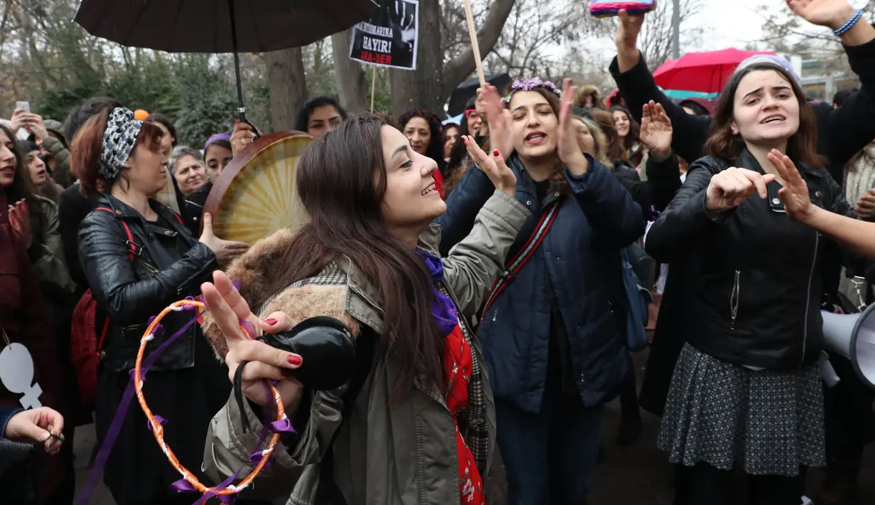 Seorang wanita bernyanyi dan menari saat berkumpul untuk memperingati Women's Day atau Hari Perempuan Internasional di Ankara, Turki, Kamis (8/3). (ADEM ALTAN/AFP)