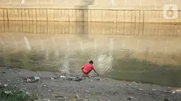Anak-anak bermain di bantaran Sungai Ciliwung yang mengering, kawasan Kampung Melayu, Jakarta, Jumat (8/11/2019). Curah hujan yang tidak menentu menyebabkan sebagian bantaran Ciliwung masih mengalami kekeringan. (Liputan6.com/Immanuel Antonius)