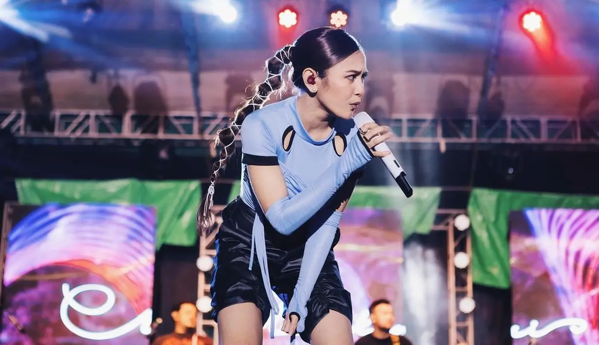 <p>Memadukan atasan bernuansa keunguan dengan detail cut-out dan sambungan lengan panjang, Mahalini kembali menghadirkan tampilan nyentrik saat manggung. Ia padukan dengan celana pendek hitam dan mengikat rambut panjangnya dengan karet yang banyak. Foto: Instagram.</p>