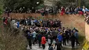 Para peserta menyusuri sungai untuk berebut bola saat mengikuti Royal Shrovetide Football Match di Ashbourne, Derbyshire, Inggris, Selasa (5/3). Pertandingan ini menghalalkan segala macam cara untuk menang. (Oli Scarff/AFP)