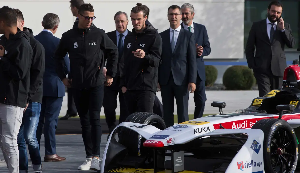 Penyerang Real Madrid Cristiano Ronaldo dan Gareth Bale melihat mobil balap Formula E yang dipamerkan saat sebuah acara promosi di Madrid, Spanyol, (23/11). (AP Photo / Paul White)