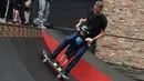 Legenda skateboard Tony Hawk bersama seorang anak Connor Curis meluncur dengan papan skateboard di Downtown Detroit (15/8). Taman skateboard ini  oleh Tony Hawk dan Ryan McGinness. (Tanya Moutzalias/Ann Arbor News-MLive.com Detroit via AP)