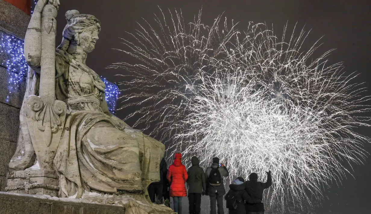 Warga menonton pesta kembang api saat perayaan Tahun Baru 2019 di pusat kota St. Petersburg, Rusia, Selasa (1/1). (AP Photo/Dmitri Lovetsky)