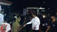 Presiden Jokowi membagikan sembako kepada warga jelang Lebaran Idul Fitri 2022. Pembagian sembako dilakukan di Pintu 2 Istana Kepresidenan Bogor, Jawa Barat, Jumat (29/4/2022) malam. (Liputan6.com/Achmad Sudarno)