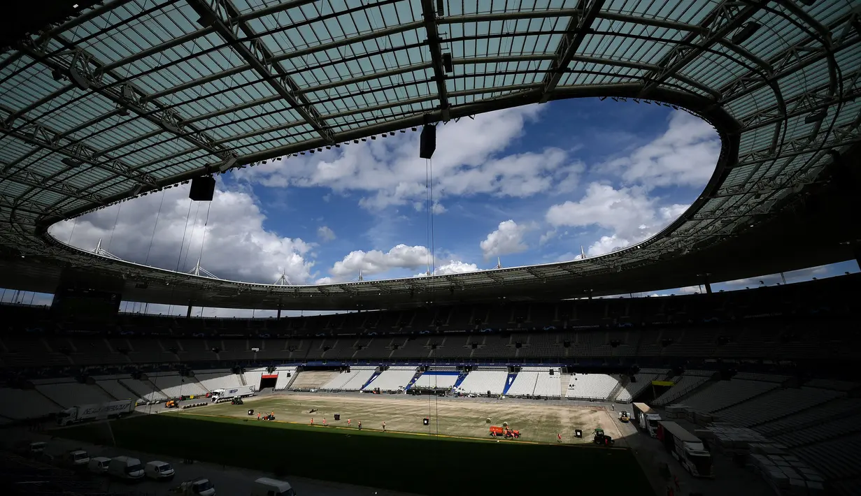 Sejumlah pekerja sedang memasang rumput hybrid baru di Stade de France, Saint-Denis, pada 24 Mei 2022 waktu setempat. Dalam waktu 48 jam, rumput baru yang ditanam di luar Barcelona, dipasang di Stade de France untuk pertandingan final Liga Champions antara Real Madrid dan Liverpool yang dijadwalkan berlangsung pada 28 Mei 2022. (AFP/Franck Fife)