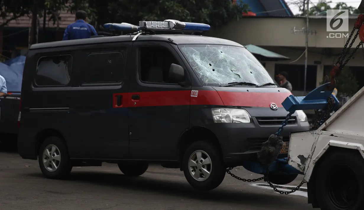 Petugas Ditlantas Polda Metro Jaya membawa mobil dinas polisi di Mapolsek Ciracas, Jakarta, Rabu (12/12). Sekelompok orang tak dikenal merusak sekitar 17 mobil dinas saat menyerang Polsek Ciracas. (Liputan6.com/Herman Zakharia)
