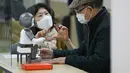 Seorang instruktur (kiri) program pendidikan membantu seorang partisipan mempelajari LIKU, fasilitator pengajaran robotik, di sebuah pusat kesejahteraan warga lanjut usia (lansia) di Distrik Yangcheon, Seoul, Korea Selatan (16/11/2020). (Xinhua/Wang Jingqiang)