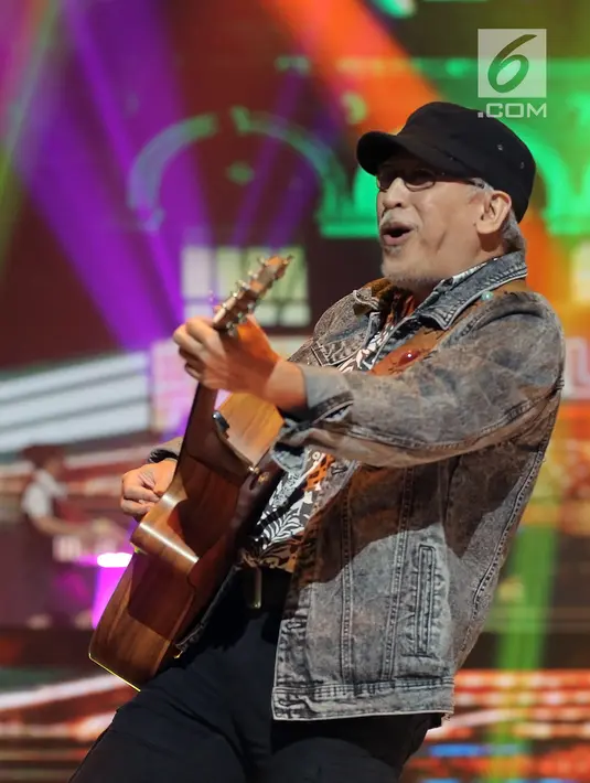 Penyanyi Iwan Fals saat Konser Raya 24 Tahun Indosiar Luar Biasa di JCC Senayan, Jakarta, Jumat (11/1). Iwan Fals bernyanyi sambil mengikuti gerakan dance Agnez Mo. (Fimela.com/Bambang Eros)