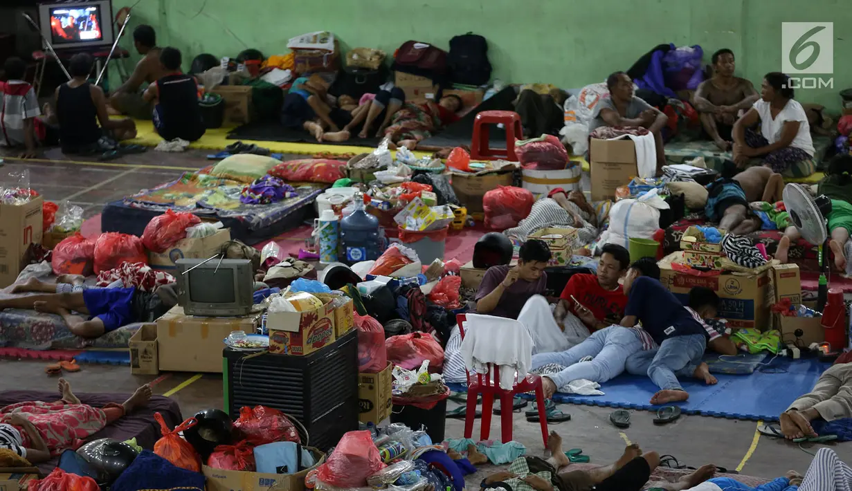 Aktivitas sejumlah pengungsi Gunung Agung di lokasi pengungsian GOR Swecapura, Klungkung, Bali, Minggu (3/12). Meski aktivitas Gunung Agung semakin menurun hingga kini, gunung di Provinsi Bali itu masih berstatus awas. (Liputan6.com/Immanuel Antonius)