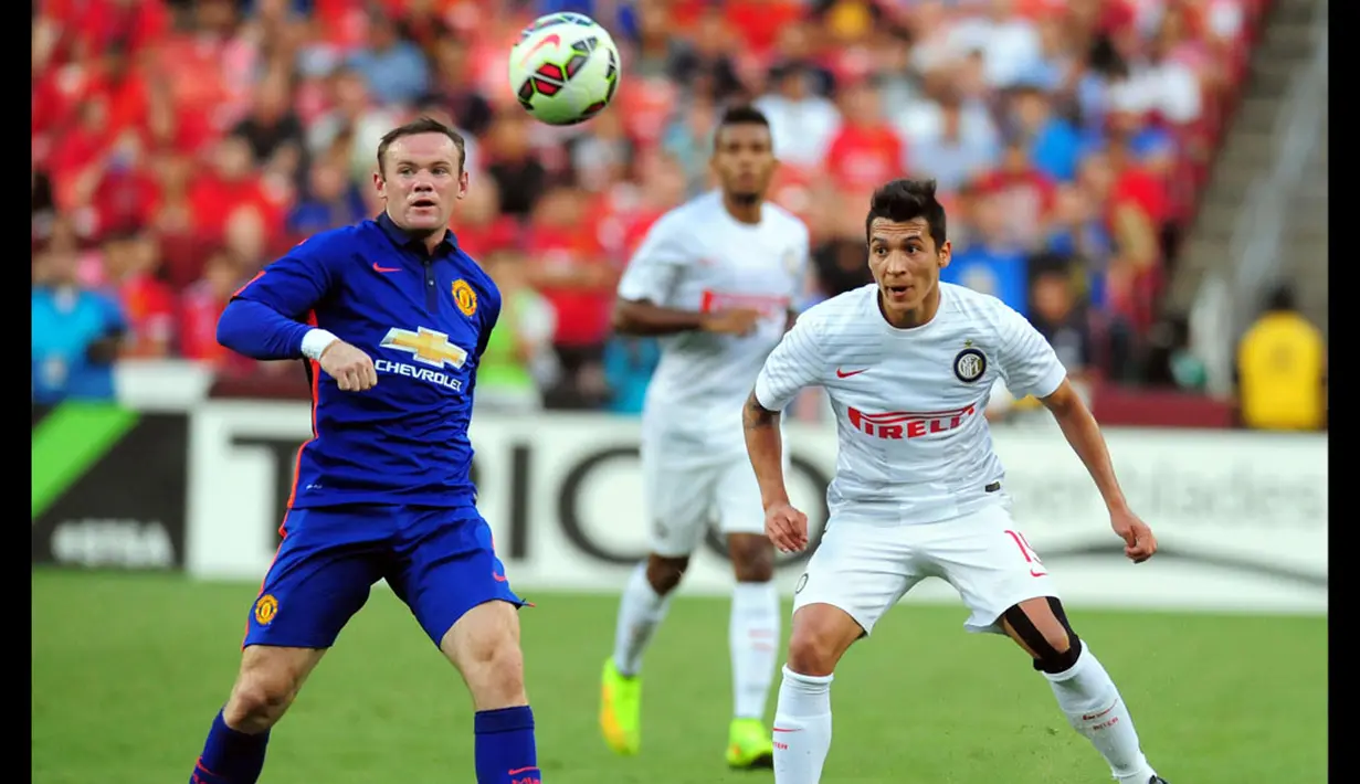 Pemain depan Manchester United, Wayne Rooney (kiri), berusaha mempertahankan bola dari kejaran Ruben Botta (Inter Milan) saat berlaga di Guines International Champions Cup di FedExField, (29/7/2014). (REUTERS/Evan Habeeb-USA TODAY Sports)