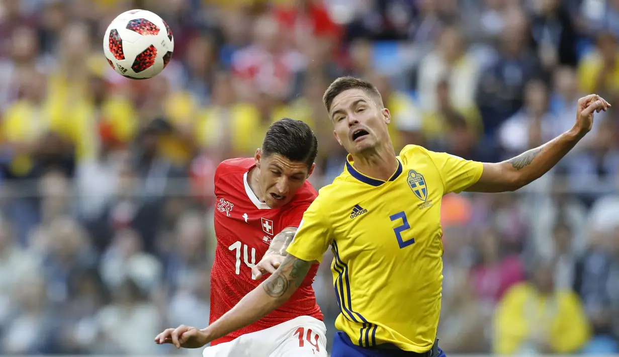 Gelandang Swiss, Steven Zuber, duel udara dengan bek Swedia, Mikael Lustig, pada babak 16 besar Piala Dunia di Stadion St Petersburg, St Petersburg, Selasa (3/7/2018). Swedia menang 1-0 atas Swiss. (AP/Efrem Lukatsky)