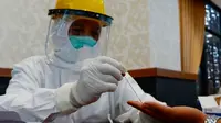 Petugas mengambil sampel darah warga Pekanbaru dalam rapid tes Covid-19. (Liputan6.com/M Syukur)