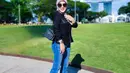 Padu padan Syahrini pakai celana jeans. Ia memadukan atasan blouse berkerah dengan kantung berwarna hitam, dengan celana jeans biru, dan hijab abu-abu muda polos, tas, dan high heels yang sama-sama berwarna hitam. [Foto: Instagram/princessyahrini]