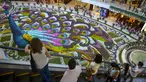Sejumlah pengunjung melihat merak raksasa selama Festival Bunga di Pusat Perbelanjaan Santa Fe di Medellin, Kolombia (3/8). Merak yang terbuat dari 182.000 bunga ini memiliki panjang 12 meter (40 kaki). (AFP Photo/Joaquin Sarmiento)