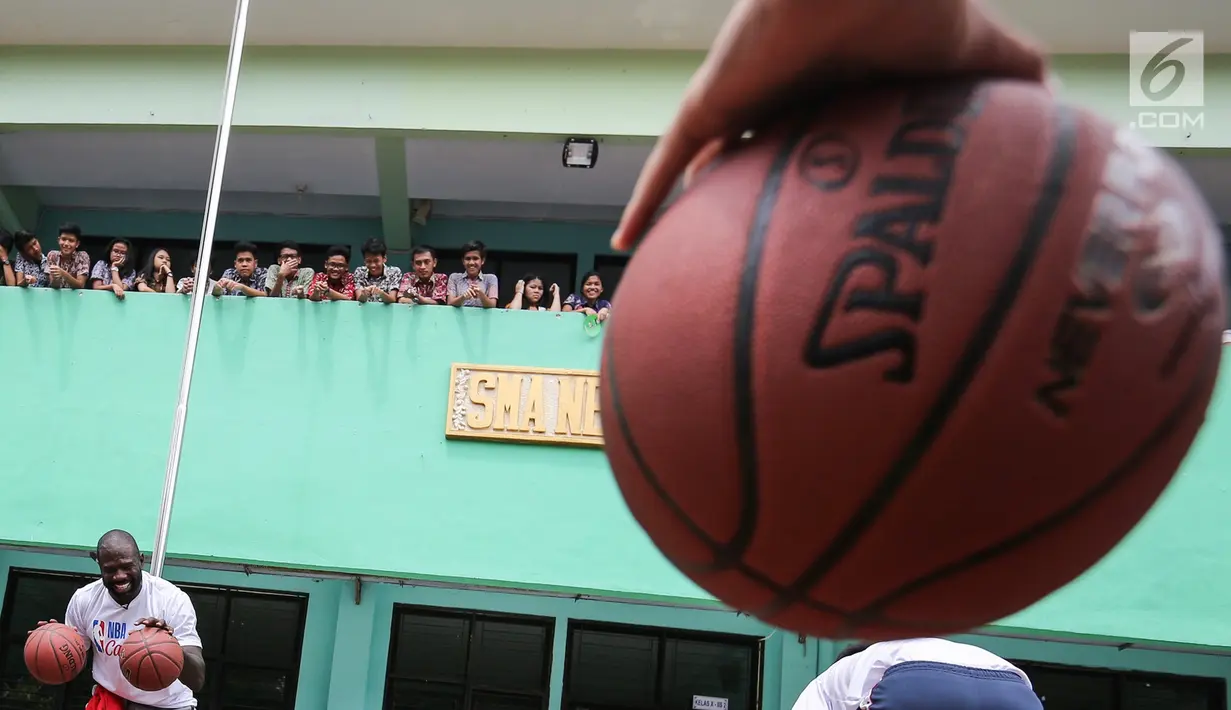 Mantan pemain NBA Jason Richardson melatih siswa-siswi pada program coaching clinic dan NBA Cares yang digelar Jr. NBA Indonesia di SMAN 82 Jakarta, Kamis (28/9). Jason Richardson merupakan Juara kontes slam dunk NBA 2002 dan 2003. (Liputan6.com/Fery Pradolo)