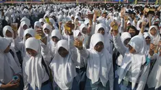 Ribuan pelajar mengangkat gelasnya saat minum jamu bersama di Alun-Alun Satya Negara Sukoharjo, Jawa Tengah, Rabu (1/4). Kegiatan tersebut dalam rangka pelestarian jamu ke masyarakat nasional maupun internasional. (Liputan6.com/Johan Tallo)
