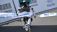 Sebuah robot melintasi garis finis dalam lomba lari setengah maraton robot humanoid di Beijing pada 19 April 2025. (Pedro PARDO/AFP)