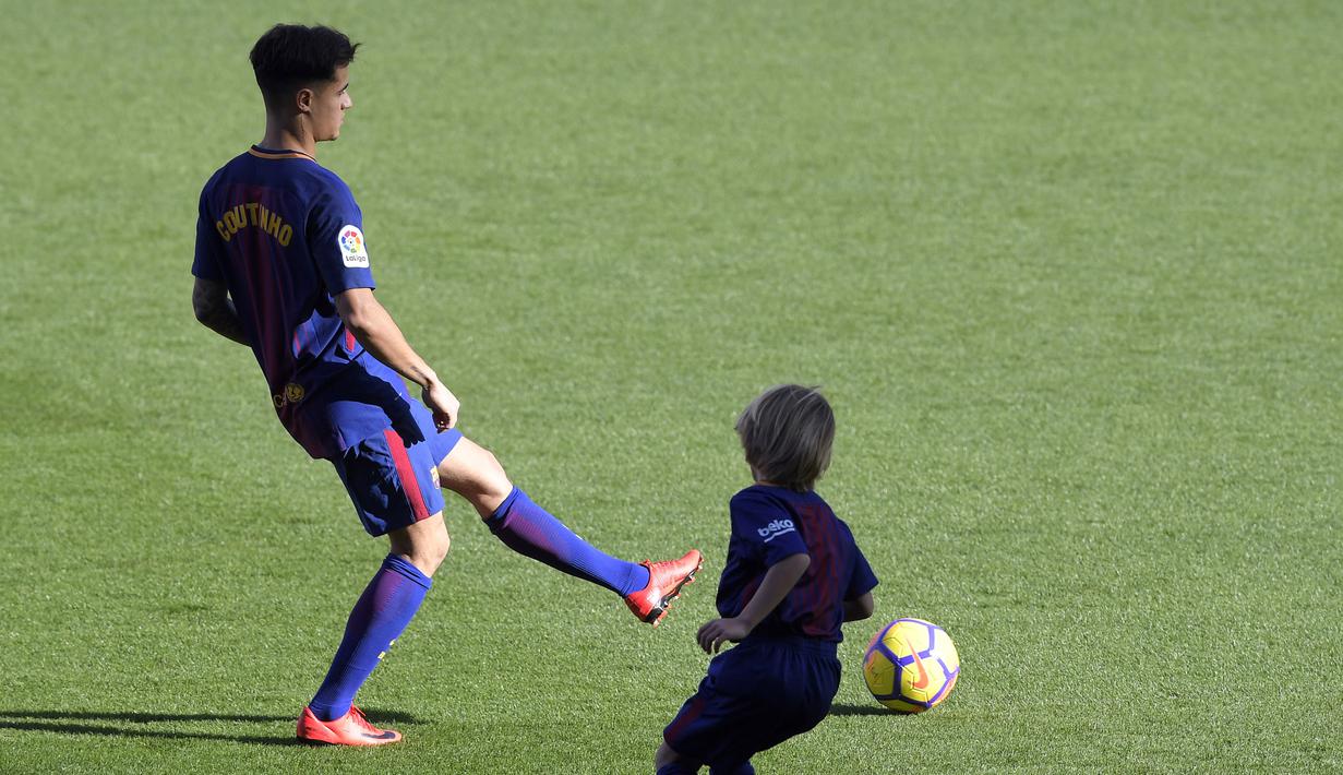 Philippe Coutinho bermain bola dengan anak-anak saat perkenalan di Camp Nou stadium, Barcelona, Spain, (8/01/2018). Coutinho bergabung dengan Barcelona dari Liverpool dengan nilai transfer sebesar 160 juta euro. (AFP/Lluis Gene)