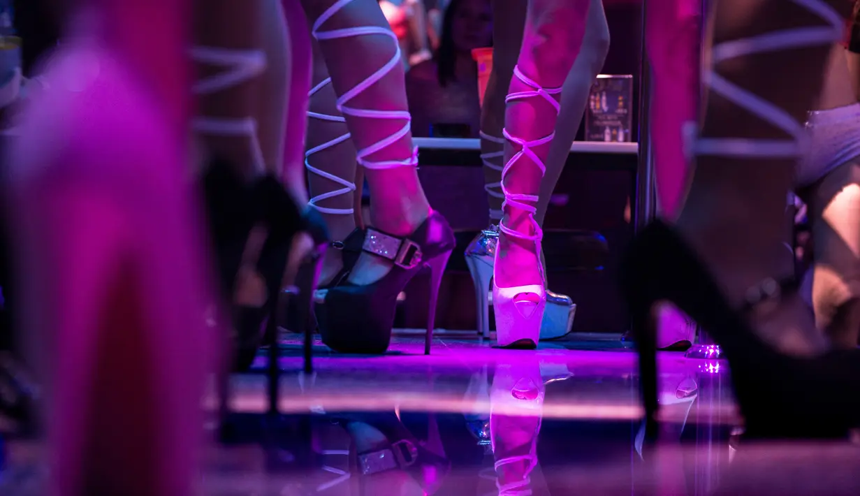 Penampilan para wanita penghibur di sebuah bar di kawasan Walking Street, Pattaya, Thailand (29/3). Pattaya dikenal sebagai Sin City dan The World Sex Capital yang banyak dikunjungi wisatawan internasional untuk wisata seks. (AFP/ Roberto Schmidt)