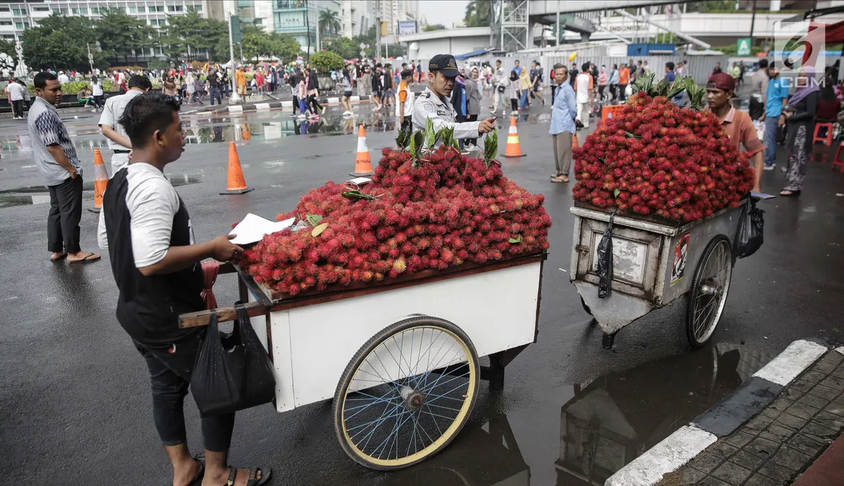 Petugas Dinas Perhubungan menindak tegas pedagang yang berjualan di Car Free Day (CFD) di kawasan Bunderan HI, Jakarta, Minggu (4/2). Penindakan ini dilakukan agar kawasan CFD tertib dan rapih. (Liputan6.com/Faizal Fanani)