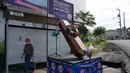 Warga berjalan dekat peti mati dengan tulisan, "Anda memutuskan, di rumah atau di dalam kotak ini", sebagai bagian dari kampanye pemerintah setempat di jalan-jalan kotamadya Escuintla, Guatemala City pada 21 Juli 2020. Kampanye itu sebagai upaya menghentikan penyebaran COVID-19. (Johan ORDONEZ/AFP)
