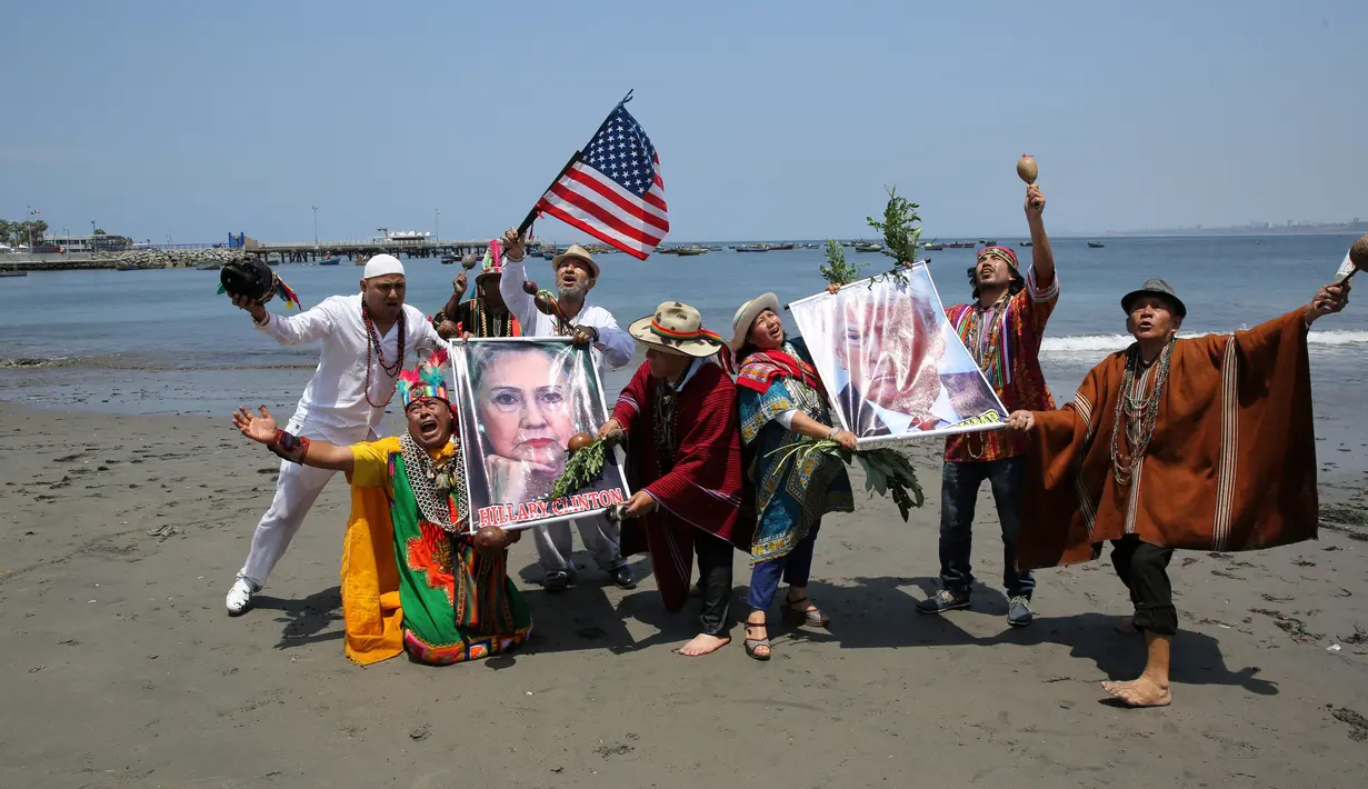 Dukun Peru melakukan ritual prediksi pada poster bergambar Capres AS dari Partai Demokrat, Hillary Clinton dan rivalnya dari Partai Republik, Donald Trump menjelang pemilihan presiden AS, di Lima, Peru, Senin (7/11). (REUTERS/Mariana Bazo)