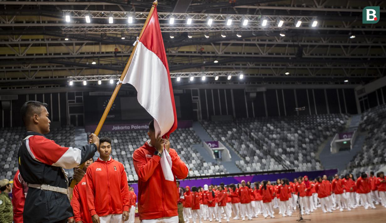 Para atlet melakukan ritual mencium bendera saat acara pengukuhan kontingen Indonesia di Istora Senayan, Jakarta, Minggu (5/8/2018). Pada Asian Games XVIII, Indonesia menurunkan 938 atlet. (Bola.com/Vitalis Yogi Trisna)