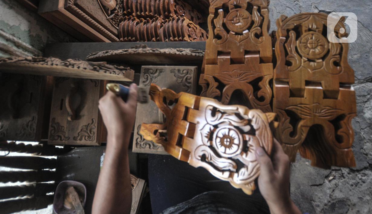 Pekerja menyelesaikan pembuatan rehal atau meja untuk Al-qur’an di Toko Mabruri 12, Klender, Jakarta, Rabu (13/4/2022). Harga rehal di toko ini dibanderol mulai dari Rp50.000 hingga Rp300 ribu per buah, tergantung ukuran dan jenis kayu. (merdeka.com/Iqbal S Nugroho)