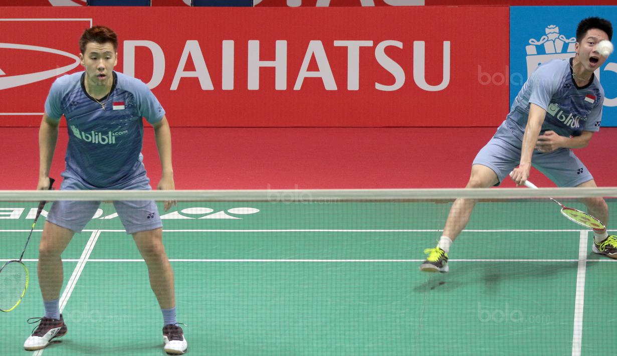 Kevin Sanjaya (kanan) melepaskan smash ke arah Rian Agung/Hendra Setiawan pada babak kedua Daihatsu Indonesia Master 2018 di Istora Senayan, Kamis (25/1/2018). Kevin/Marcus menang 21-16 23-2.1 (Bola.com/Nick Hanoatubun)