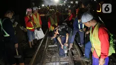 Sejumlah petugas merevitalisasi wesel rel di Stasiun KA Gambir, Jakarta, Kamis (14/2/2020) malam. PT KCI dan PT KAI Daop 1 Jakarta mengganti wesel rel di Stasiun Gambir dan Stasiun Jakarta Kota secara paralel yang akan berlangsung pada 13-23 Februari 2020. (Liputan6.com/Herman Zakharia)