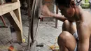Pengrajin memintal benang saat menyelesaikan pembuatan tenun ikat di salah satu industri rumahan di Desa Bandar Kidul, Kediri, Jawa Timur, Sabtu (29/9). Saat ini banyak pengrajin tenun ikat Bandar Kidul terpaksa gulung tikar. (Merdeka.com/Iqbal Nugroho)