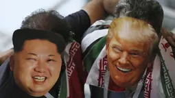 Suporter Iran memakai topeng wajah dari Donald Trump dan Kim Jong-un saat menonton laga grup B Piala Dunia melawan Spanyol di Kazan Arena, Kazan, Rabu (20/6/2018). Iran kalah 0-1 dari Spanyol. (AP/Eugene Hoshiko)