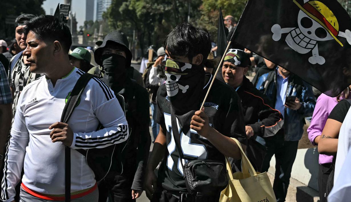 Ini adalah demonstrasi kedua yang bertujuan untuk memprotes kebijakan keamanan pemerintah sayap kiri. Tampak dalam foto, seorang pengunjuk rasa memegang bendera berlogo manga populer Jepang, One Piece, simbol yang diadopsi oleh gerakan protes Gen Z di seluruh dunia, dalam sebuah demonstrasi yang diserukan oleh Generasi Z untuk menentang pemerintahan Presiden Meksiko, Claudia Sheinbaum, di sepanjang Reforma Avenue di Mexico City pada 20 November 2025. (CARL DE SOUZA/AFP)