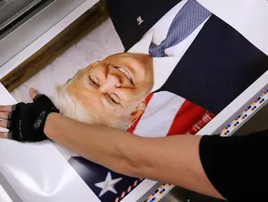 Pekerja menyelesaikan proses pembuatan foto Presiden Amerika Serikat Donald Trump di Washington DC (4/12). Ribuan foto resmi Donald Trump ini akan diedarkan ke lebih 1.600 kantor federal di seluruh dunia. (Chip Somodevilla/Getty Images/AFP)