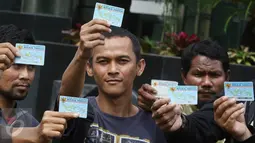 Aktivis Koalisi Masyarakat Sipil menunjukan KTP Elektronik saat melakukan aksi di depan Gedung KPK, Jakarta, Minggu (12/3). Aksi ini bertujuan untuk menuntut agar KPK mengusut tuntas kasus mega korupsi KTP Elektronik. (Liputan6.com/Immanuel Antonius)