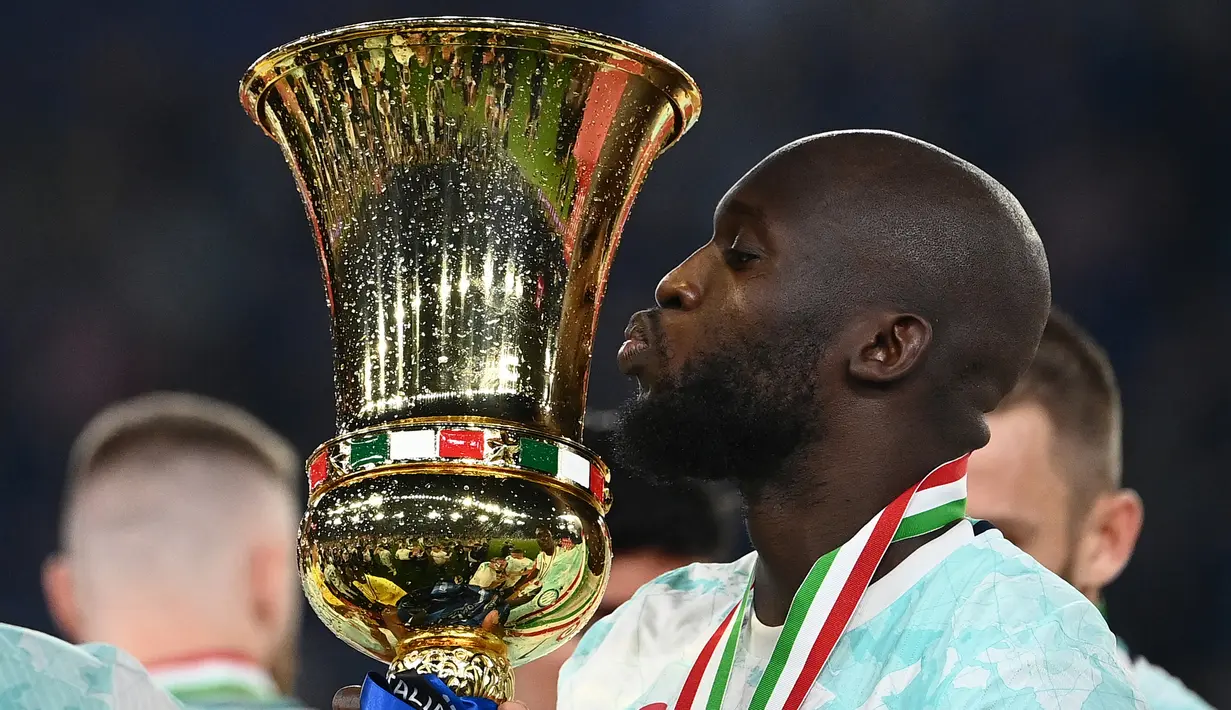 Selebrasi striker Inter Milan, Romelu Lukaku dengan mencium trofi Coppa Italia 2022/2023 setelah mengalahkan Fiorentina pada laga final di Olimpic Stadium, Roma (24/5/2023). Al Hilal sempat menawari Romelu Lukaku  untuk meninggalkan Chelsea dengan nilai kontrak 45 juta poundsterling atau setara Rp818 miliar selama dua tahun. Dengan alasan masih ingin bermain di Eropa, Romelu Lukaku pun menolaknya. (AFP/Isabella Bonotto)