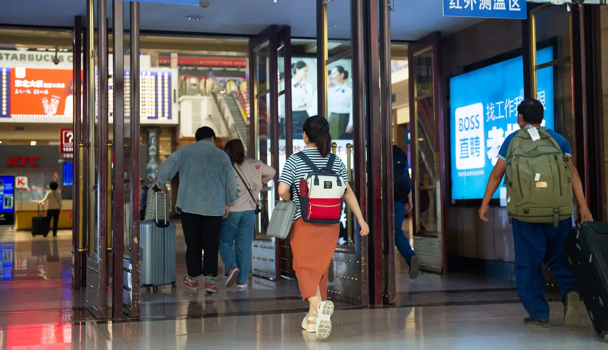 Para penumpang berjalan melewati area pemantauan suhu tubuh di aula Stasiun Kereta Api Beijing di Beijing, ibu kota China (18/6/2020). (Xinhua/Chen Zhonghao)