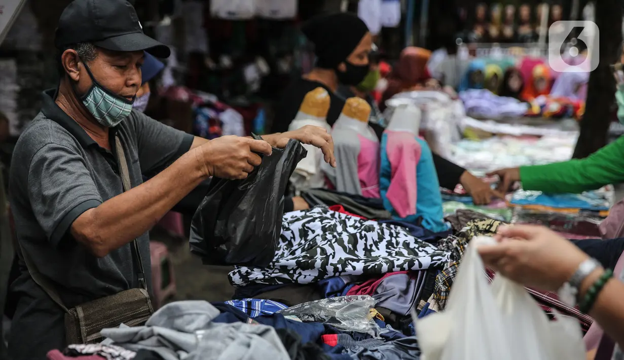 Seorang pedagang menggunakan kantong plastik di Kawasan Pasar Jatinegara, Jakarta, Selasa (30/6/2020). Mulai 1 Juli 2020 penggunaan kantong plastik sekali pakai dilarang di mal, toko swalayan, dan pasar tradisional di DKI Jakarta. (Liputan6.com/Faizal Fanani)