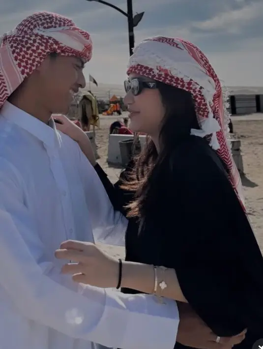 Azizah Salsha dan Pratama Arhan berkunjung ke gurun pasir di Qatar. Keduanya kompak mengenakan sorban merah di kepala masing-masing. [@azizahsalsha_]