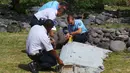 Polisi memeriksa potongan besi mirip badan pesawat yang diduga milik MH370 di pantai Saint - Andre, Perancis, Rabu (29/30/2015).  Puing sepanjang dua meter itu tampak mirip bagian dari sayap  pesawat. (REUTERS/Prisca Bigot)