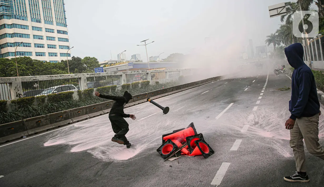 Polisi menembakkan gas air mata ke arah para pengunjuk rasa di depan pintu gerbang gedung DPR RI, Jakarta, Senin (11/4/2022). Situasi mulai memanas akibat sejumlah pengunjuk rasa melempari petugas dengan berbagai benda lainnya. (Liputan6.com/Faizal Fanani)