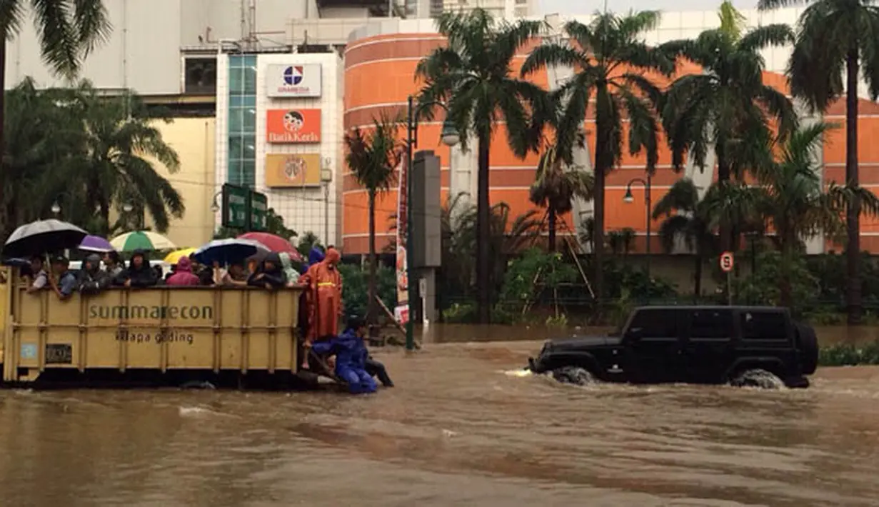 Sejumlah orang menaiki truk untuk melewati banjir di depan Mal Kelapa Gading, Jakarta Utara, Selasa (10/2/2015). (Axel Widjaja)
